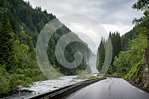 Norwegian road between river and mountains.