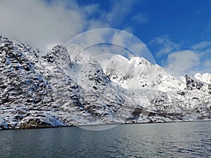 Norwegian sailing trollfjord and coast during a winter sail with snow