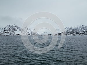 Norwegian sailing trollfjord and coast during a winter sail with snow