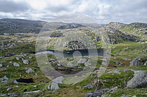 Norwegian tundra landscape with rocky hills and lake