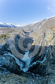 Norwegian Voringfossen waterfall in early spring, leftover ice left over from winter in the Bjoreio valley in the Eidfjord