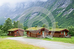 Norwegian wooden houses with grass on the roof at the foot of the mountain