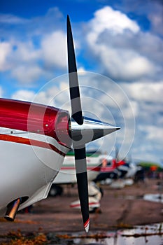 The nose of the aircraft with a propeller on the sky background