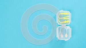 Nose clip and swimming earplug in a transparent case on a blue background