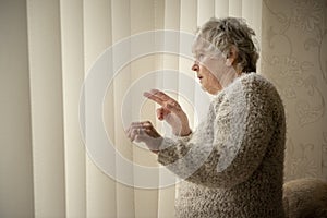 Nosey neighbour, senior woman looking through window