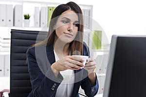 Nostalgic businesswoman with a cup of coffee in an office