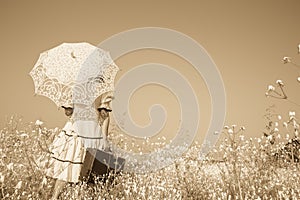 Nostalgic old photo in sepia color. Girl with her umbrella walking alone and searching her way.