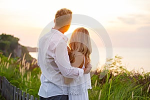 Nostalgic and romantic couple looking at sunset photo