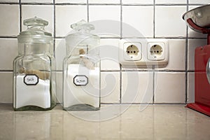 Nostalgic still life of retro kitchen with two jars salt and sugar on the counter, Selective focus on salt.