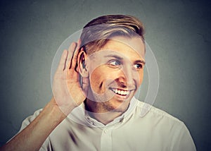 Nosy man secretly listening in on conversation hand to ear