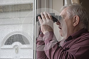 Nosy neighbor looking through window with binoculars