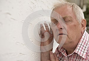 Nosy neighbour holding a glass up to the wall