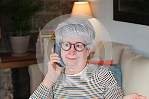 Nosy senior woman using landline phone