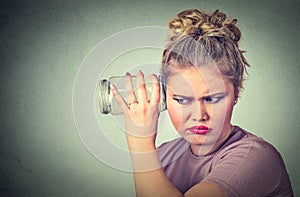 Nosy woman with glass jar listens to gossip behind the wall