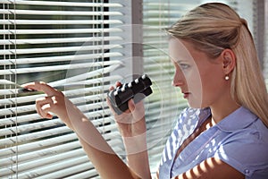 Nosy woman peering through some blinds photo