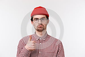 Not bad, really good job. Close-up portrait satisfied serious-looking bearded young man in beanie and glasses make