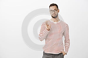 Not bad, like your idea, good job. Satisfied impressed attractive mature guy in glasses and striped clothes, showing ok