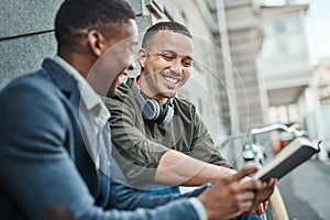 Not a boardroom, its even better. two young businessmen having an informal meeting against an urban background.