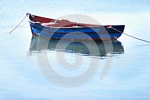 Not a breath of wind today. Shot of an empty fishing boat floating on calm waters.