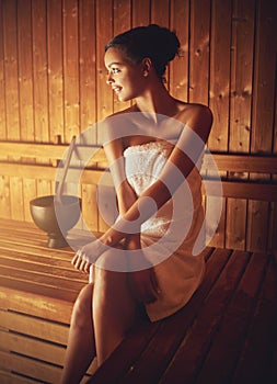Not a care in the world. a young woman relaxing in the sauna at a spa.