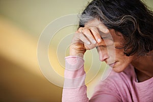 Not feeling too well today. Shot of a mature woman resting her head on her hand.
