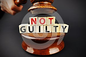 Not guilty verdict or court decision with judge gavel on dark background