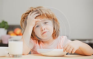 Not hungry. Kid refusing to eat. Child have no appetite. Upset little kid refuse to eat organic cereals with milk. Child