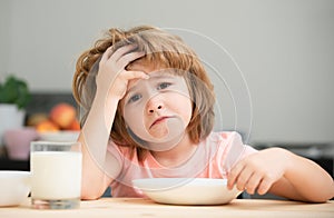 Not hungry. Kid refusing to eat. Child have no appetite. Upset little kid refuse to eat organic cereals with milk. Child