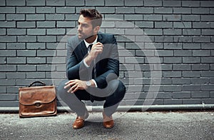 Not just a successful businessman, but also a style icon. Shot of a handsome young businessman posing against a grey