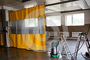 Not large car wash room with yellow waterproof curtain.
