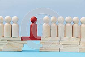 Not like everyone. Business risk. Leadership and superiority. People figures on bridge, one red person miniature on gap photo