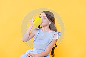 Not my cup of tea. Making sip. Drink enough water. Girl kid hold mug yellow background. Lovely child hold mug. Drinking