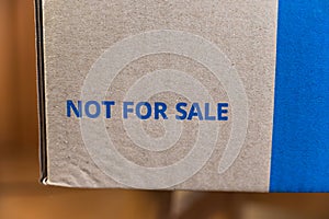 Not for sale. Blue lettering on a brown cardboard box. Volunteerism, humanitarian aid to the hungry and needy concept. Selective