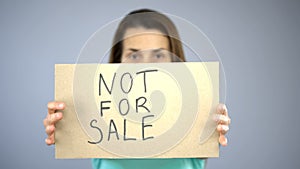Not for sale sign in woman's hands, sexual slavery, human trafficking, assault
