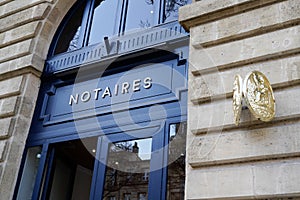 Notaire france golden text and symbol means notary office french sign on wall facade photo
