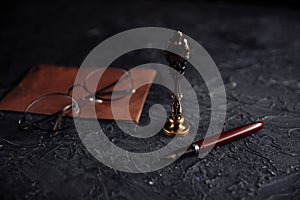 Notary public tools: old notarial wax seal, pen, glasess and envelope on a table