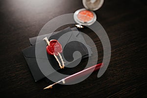 Notary tools. Black envelopes with red wax seal on a dark wooden table
