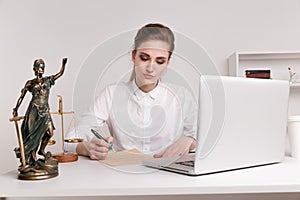 Notary woman writing on the documents, typing on her computer