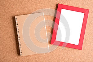 Note book and blank frame on wooden table