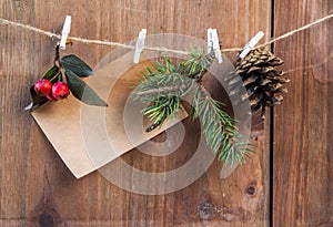 Note, Christmas tree branch, pine cone and winter berries on a rope with clothespins