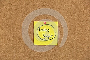 Note on a cork board with writing ladies night out.