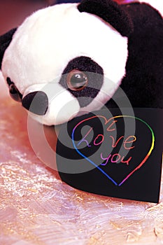 Note I love you for Valentines Day with cute panda toy. Art scratch paper for message