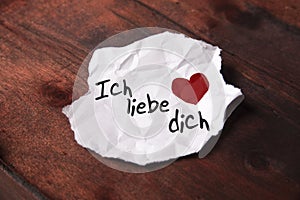 Note `Ich liebe dich` on torn slip of paper