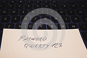Note with an insecure password on your computer keyboard. Data, information protection. Soft focus