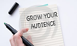 Note with the message of share your audience, with desk background