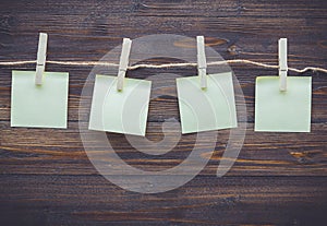 Note paper and cloth peg on wooden background