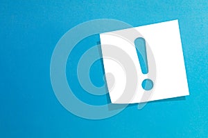 Note paper with exclamation mark on blue background photo