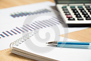 Note paper with pen, graph, calculator background