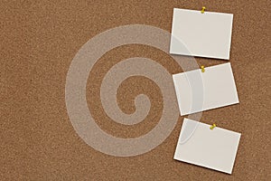 Note paper swith push pins on cork board. Empty paper pages for notes copy space