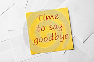 Note with phrase Time to say goodbye on paper sheets, top view